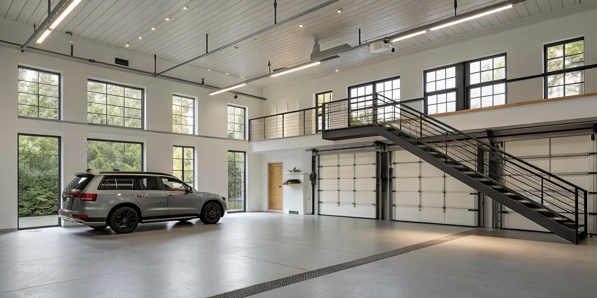 Modern lofted garage design idea with a sleek staircase and large windows to maximize space.