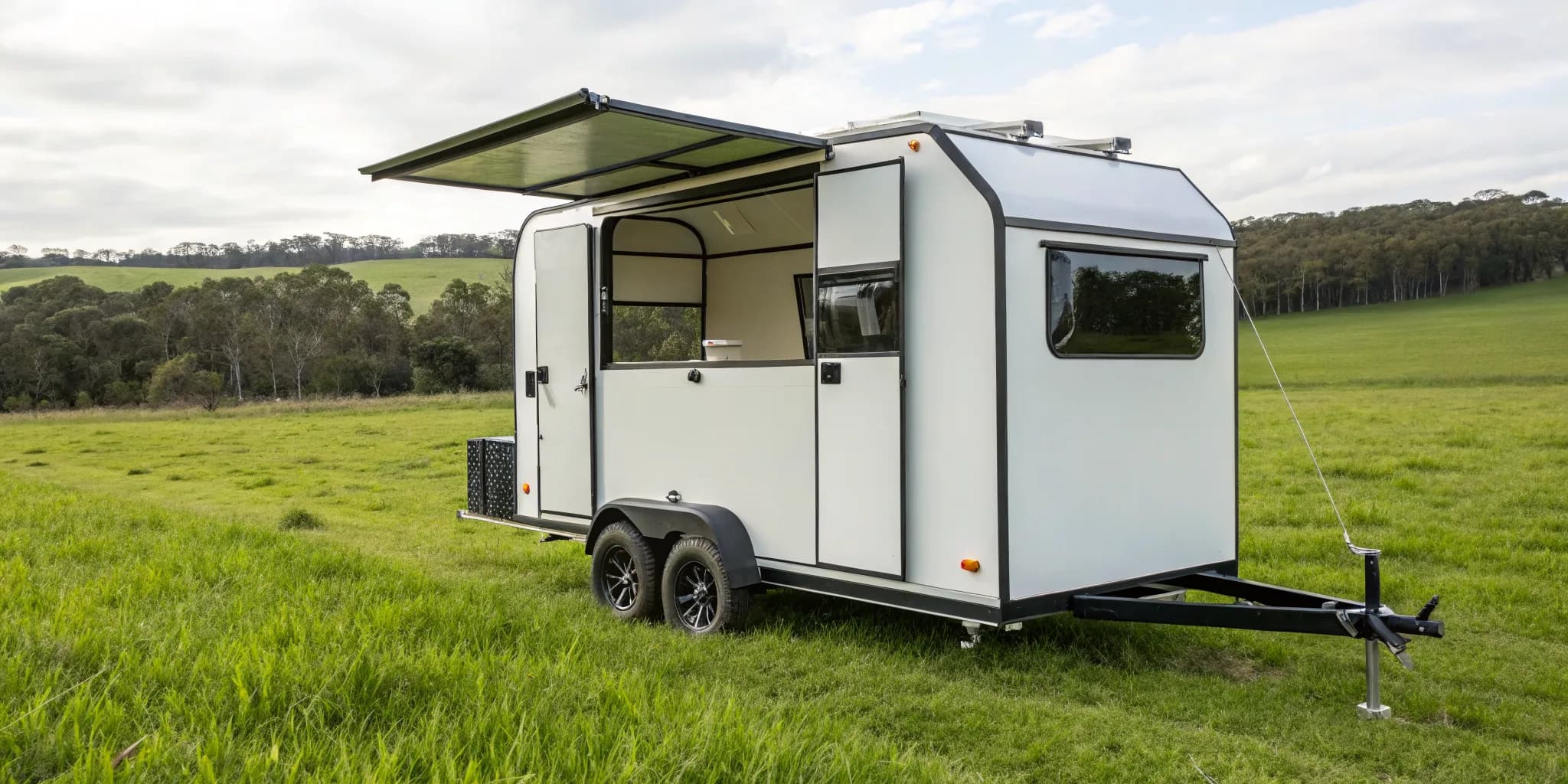 Modern mobile chicken caravan on a green pasture for rotational grazing.